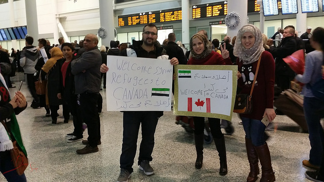 Canadians welcoming the first Syrian refugee family at Pearson Airport, Toronto. Photo credit: Domnic Santiago
